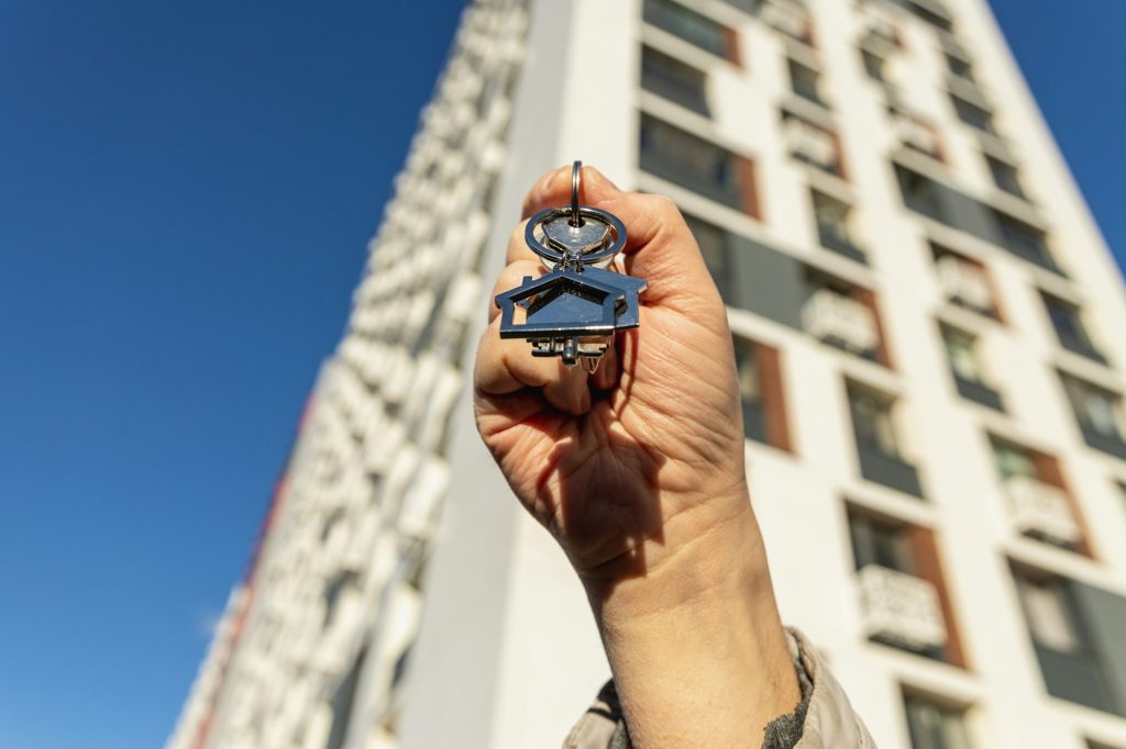 male hand holding house key,real estate agent.